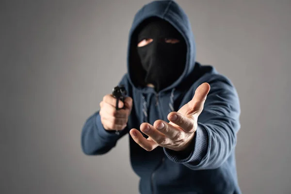 Maschio criminale con una pistola estorce denaro — Foto Stock