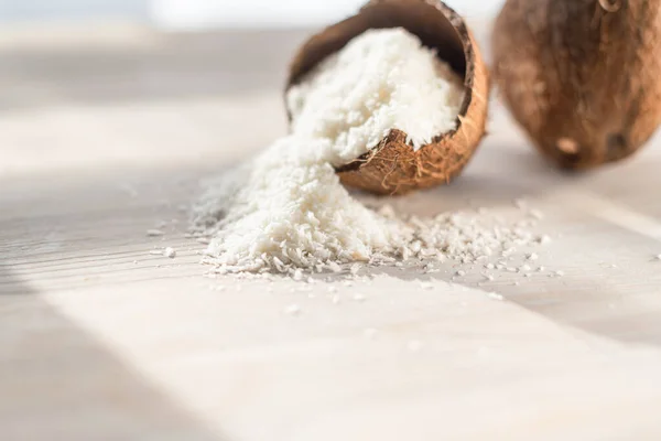 coconut flakes lies in a coconut shell, cut into two halves