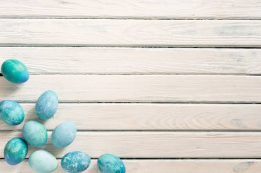 Beyaz bir arka planda, sarı bir plaka içinde mavi mermer yumurtalar vardır. Paskalya sembolü olarak yatar.