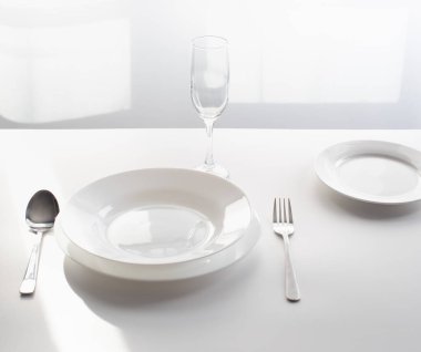 Masanın üzerindeki çatal bıçak takımı, boş bir restoranın penceresinin yanında servis ediliyor. Bir salgın sırasında halka açık alanları ve restoranları kapatma konsepti olarak.