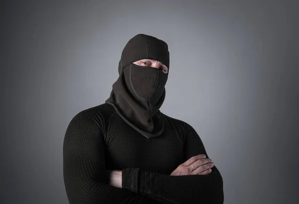 Człowiek w kominiarce, jako pojęcie sił specjalnych lub ekstremistycznych ubrań, stoi z przebiegłym spojrzeniem. — Zdjęcie stockowe