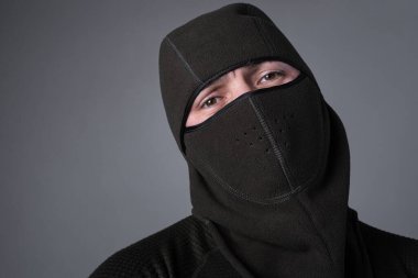 Kar maskeli bir adam, özel kuvvetler ya da suçlu kavramı olarak, tehditkar bir bakışla duruyor.