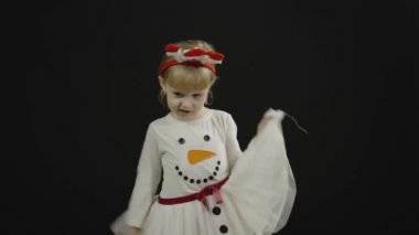 Kardan adam kostümlü mutlu küçük kız bebek. Yüz yap, dans et.