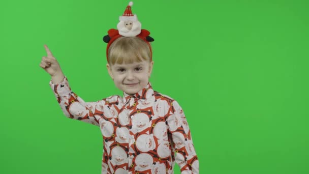 Szczęśliwa, piękna dziewczynka w koszuli ze Świętym Mikołajem. Święta. Klucz chromowy — Wideo stockowe