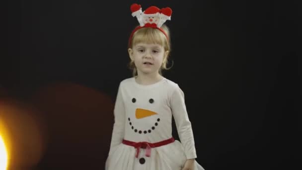 Joyeux bébé fille en costume de bonhomme de neige. Faire des visages, danser — Video