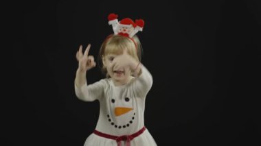 Kardan adam kostümlü mutlu bir kız bebek. Noel zamanı. Yüz yap, dans et.