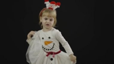 Kardan adam kostümlü mutlu bir kız bebek. Noel zamanı. Yüz yap, dans et.