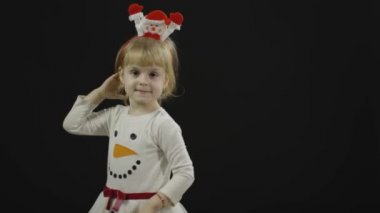 Kardan adam kostümlü mutlu bir kız bebek. Noel zamanı. Yüz yap, dans et.