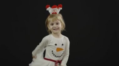 Kardan adam kostümlü mutlu bir kız bebek. Noel zamanı. Yüz yap, dans et.