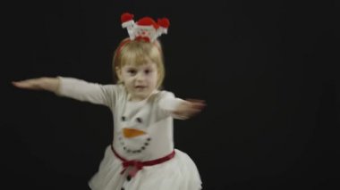 Kardan adam kostümlü mutlu bir kız bebek. Noel zamanı. Yüz yap, dans et.