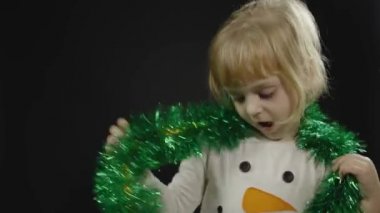 Kardan adam kostümlü mutlu bir kız bebek. Noel zamanı. Yüz yap, dans et.