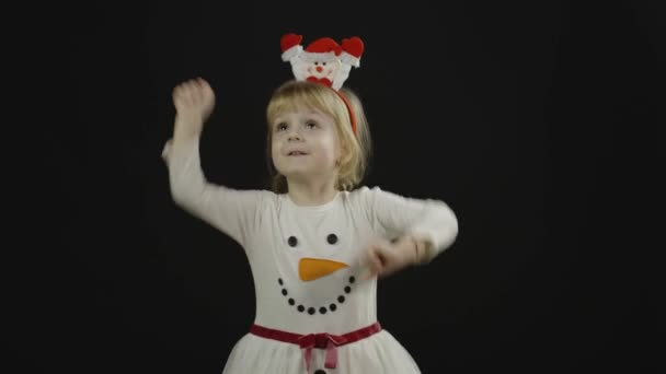 Feliz niña hermosa en traje de muñeco de nieve. Navidad. Hacer caras, bailar — Vídeo de stock