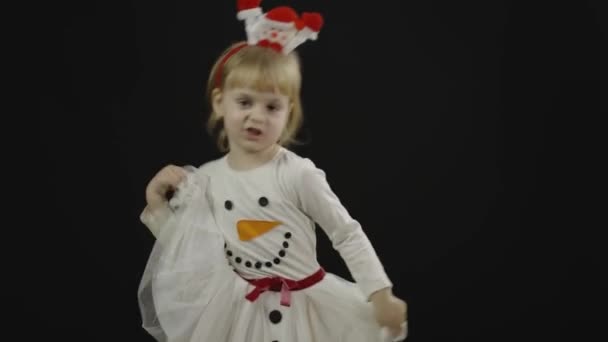 Joyeux bébé fille en costume de bonhomme de neige. Noël. Faire des visages, danser — Video