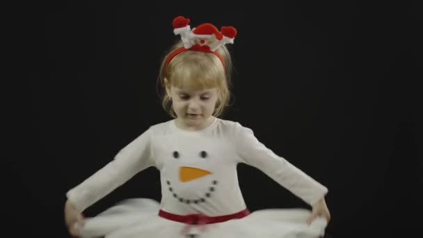 Boldog gyönyörű kislány hóember jelmezben. Karácsonykor. Vágj pofákat, táncolj — Stock videók
