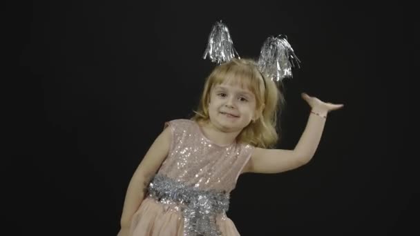 Feliz niña hermosa con vestido brillante. Navidad. Hacer caras, bailar — Vídeo de stock