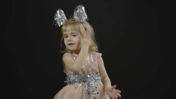 Happy beautiful little baby girl in glossy dress. Christmas. Make faces, dance — Stock Video