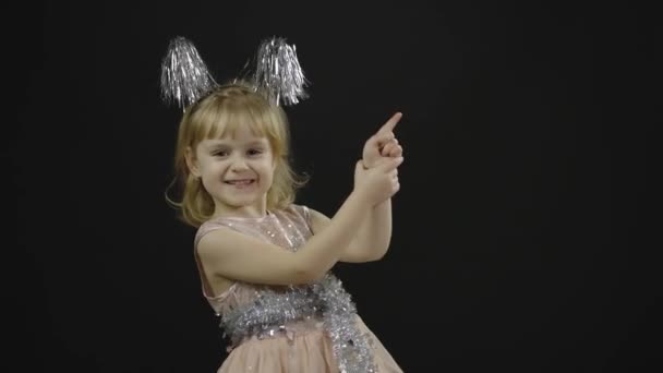 Glücklich schöne kleine Mädchen in glänzendem Kleid. Weihnachten. Gesichter machen — Stockvideo