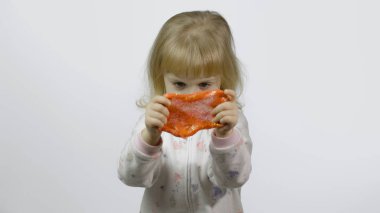 El yapımı balçıkla oynayan bir çocuk. Çocuk portakal sümüğü yaparken eğleniyor