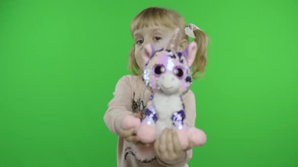 Ragazza positiva in felpa che balla con giocattolo unicorno. Un bambino felice. Chiave cromatica — Video Stock