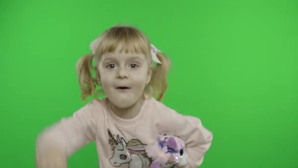 穿着运动衫，与独角兽玩具共舞的积极女孩。 快乐的孩子 Chroma键 — 图库视频影像