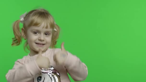 Дівчинка у спітчері єдинорога. Дитина показує пальці вгору. Chroma Key — стокове відео