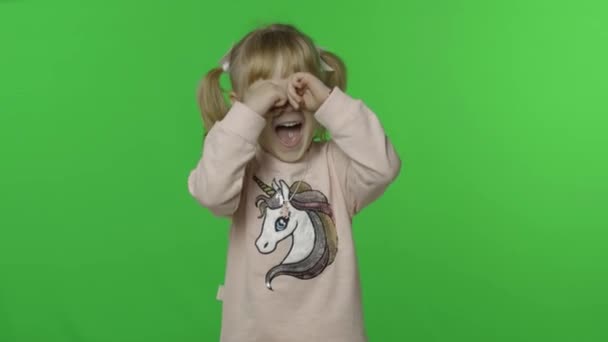 Una chica con sudadera unicornio hace caras y llora. Feliz niña. Clave de croma — Vídeos de Stock
