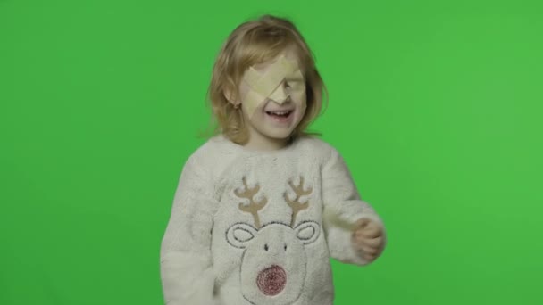 Chica positiva en suéter con un ciervo. Ojos pegados con cinta adhesiva. Clave de croma — Vídeos de Stock