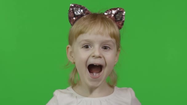 Mädchen mit Katzenstirnband versteckt Gesicht hinter Händen. glückliches vierjähriges Kind — Stockvideo