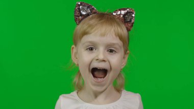 Saç bandı takmış kedi kulaklı bir kız şaşkınlık gösteriyor. Dört yaşında mutlu bir çocuk.