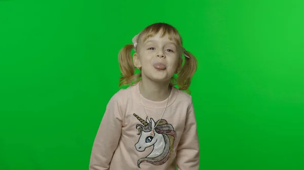 Chica con sudadera de unicornio. Feliz niño de cuatro años de edad mostrar la lengua. Clave de croma —  Fotos de Stock