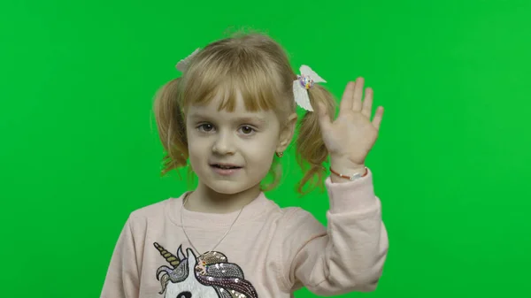 Ragazza positiva in felpa unicorno agitando le mani. Felice bambino di quattro anni — Foto Stock