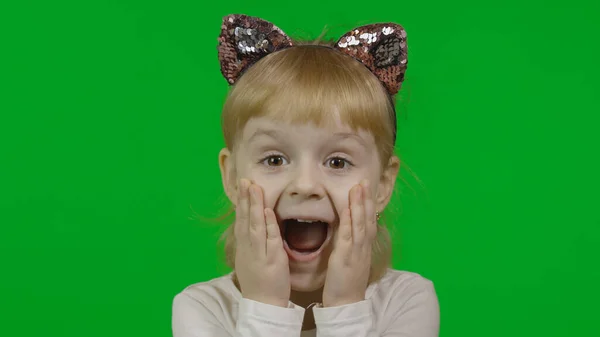 Flicka i pannband med kattöron visar häpnad. Lyckligt fyraårigt barn — Stockfoto