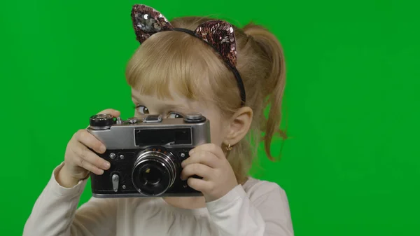 Menina na cabeça do gato tirando fotos em uma câmera de foto retro velho. Chave Chroma — Fotografia de Stock