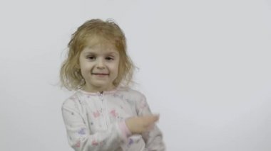 Pijamalı küçük kız sinek öpücüğü veriyor. Beyaz arkaplan