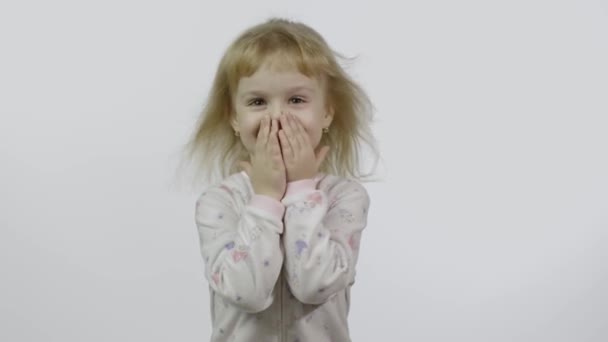 La bambina in pigiama si diverte e fa le facce. Fondo bianco — Video Stock