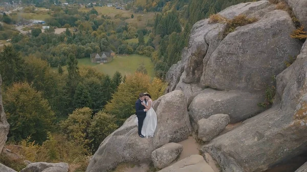 Os recém-casados estão em uma alta inclinação da montanha. Noivo e noiva. Vista aérea — Fotografia de Stock