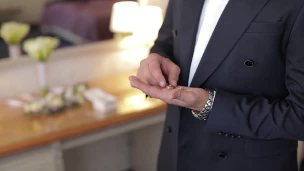 Handsome groom holds wedding rings in his hand. Wedding morning. Businessman — Stock Video