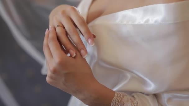 Gyönyörű és szép menyasszony, hálóingben, megérinti az eljegyzési gyűrűjét. — Stock videók