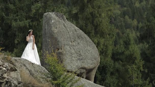 Hermosa y encantadora novia de pie en las colinas de montaña. Mujer enamorada — Vídeos de Stock