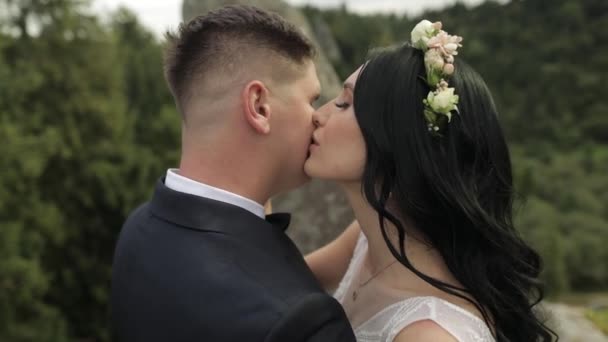 Novio con novia de pie en las colinas de la montaña. Pareja de boda enamorada — Vídeo de stock