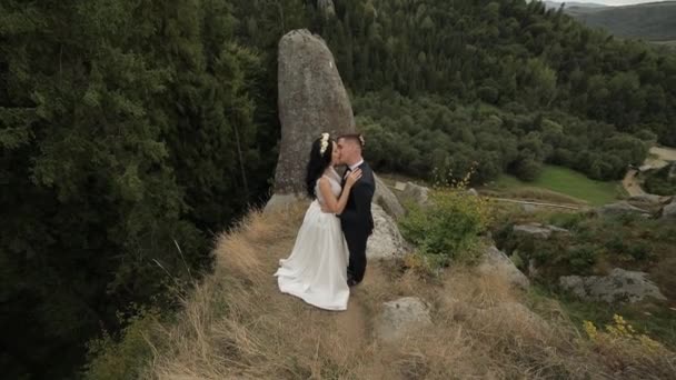 Groom with bride standing on the mountain hills. Wedding couple. Newlyweds — 비디오