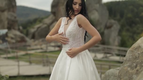Linda e adorável noiva em pé nas colinas da montanha. Mulher apaixonada — Vídeo de Stock