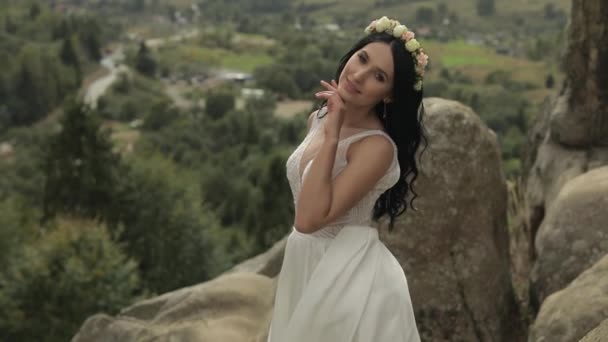 Hermosa y encantadora novia de pie en las colinas de montaña. Mujer enamorada — Vídeo de stock