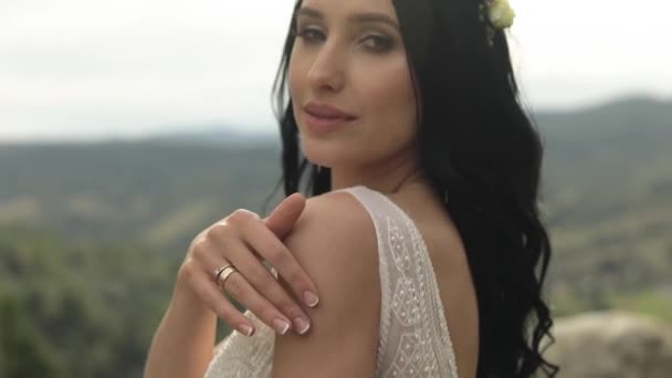 Hermosa y encantadora novia de pie en las colinas de montaña. Mujer enamorada — Vídeos de Stock