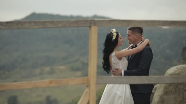 新郎新婦は山の丘の上に立っている。結婚式のカップル新婚旅行だ — ストック動画