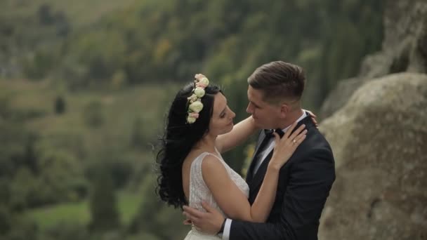 Brudgum med brud stående på bergen. Bröllopspar. Nygifta — Stockvideo