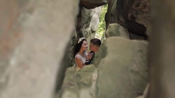 Brilho com noiva em pé na caverna de colinas de montanha. Casamento casal apaixonado — Vídeo de Stock