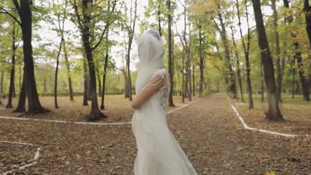 Noiva bonita e adorável em vestido de noiva correndo no parque. Movimento lento — Vídeo de Stock