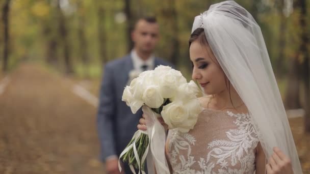 Kaukasiska brudgummen med bruden i parken. Bröllopspar. Lycklig familj. Nygifta — Stockvideo