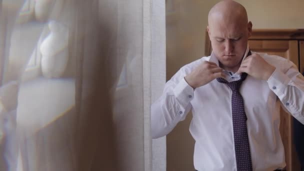 Brudgummen sätter en slips på halsen. Förbereder för att gå till bruden. Bröllopsdag — Stockvideo